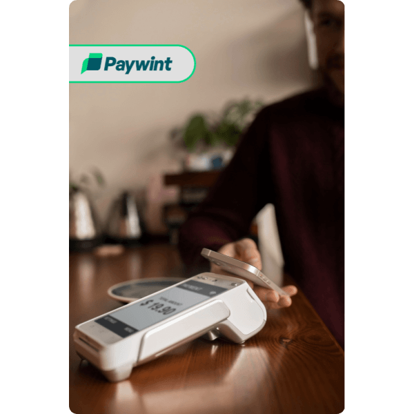 How Paywint’s POS Services Help Businesses Grow Man in a Formal Outfit Using His Smartphone Outdoors with a Security Shield Icon, Symbolizing Paywint’s Secure Payment Processing