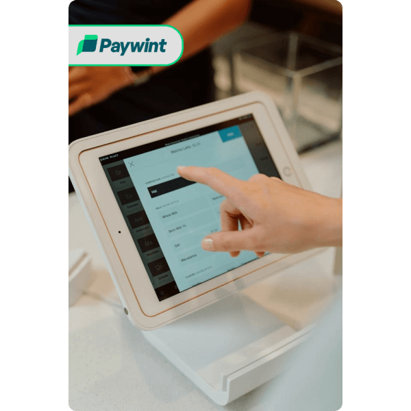 Why Businesses Prefer Paywint’s POS Services Smiling Man Using His Smartphone with the Paywint Logo, Representing a Seamless and User-Friendly Payment Experience