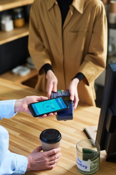 24/7 Accessibility for Businesses & Individuals A Customer Making a Secure Mobile Payment Using Paywint at a Café