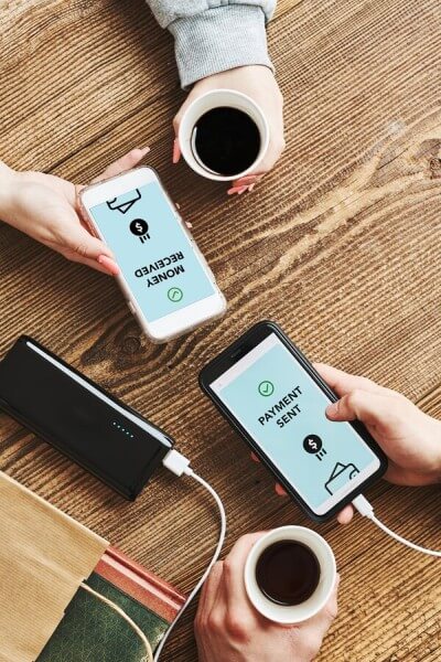 Instant and Efficient Payments Anytime Two People Making a Mobile Money Transfer While Enjoying Coffee