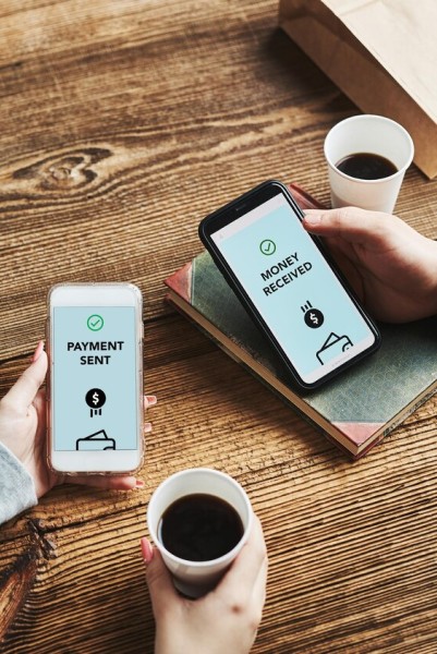 Flexible Payment Options for Vendor Pay Two People Exchanging Money Digitally Using a Mobile Payment App, Displaying "Payment Sent" and "Money Received" on Their Screens