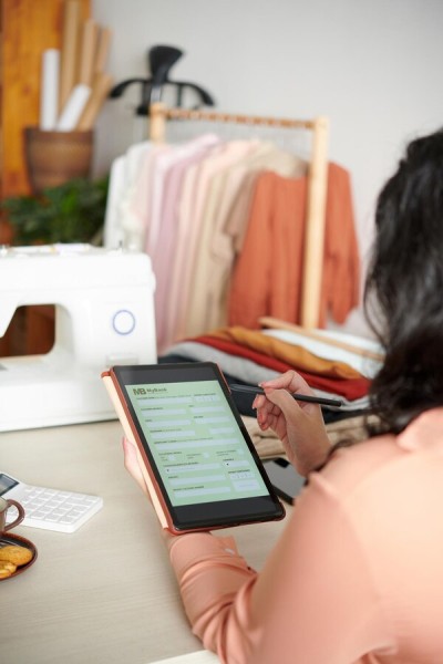 Maximize Efficiency with Automation A Business Owner Managing Product Orders on a Tablet from Her Store