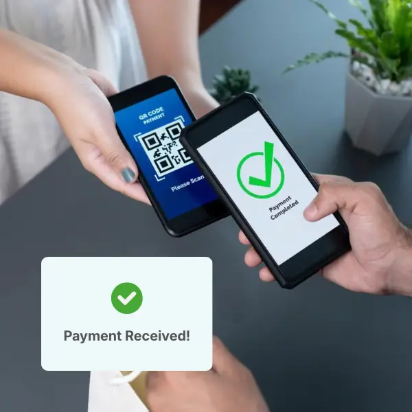 Two Hands Exchanging Smartphones Displaying Payment Screens; One Shows a QR Code and the Other Confirms Payment Completion