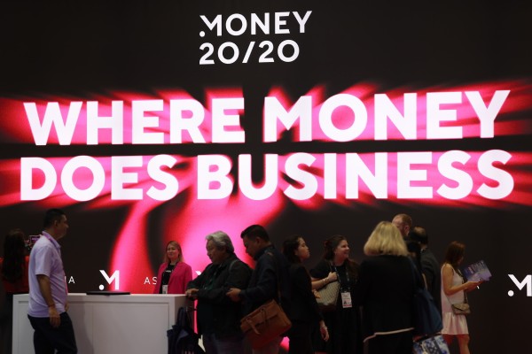 Attendees Gather in Front of a Large, Vibrant Sign for Money 20/20, Featuring the Slogan "Where Money Does Business"